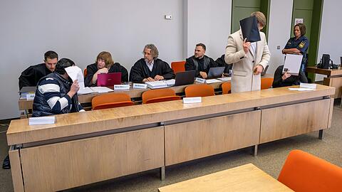 Die Angeklagten warten auf den Beginn ihres Prozesses.