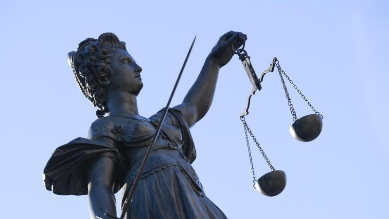 Eine Statue der Justitia steht unter freiem Himmel.