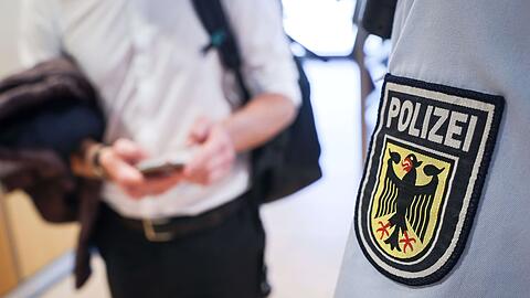 Ein Beamter der Bundespolizei kontrolliert einen Mann. (Symbolbild)