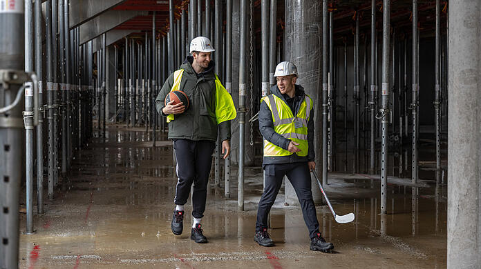 Basketballer Zipser und Eishockeyspieler Smith begutachten die Baustelle.