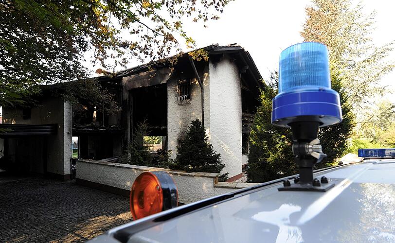 Blick auf die verkohlte Villa des Bayern-Stars Breno: Auch nach Tagen stehen noch Dienstfahrzeuge der Polizei vor dem Anwesen in Grünwald