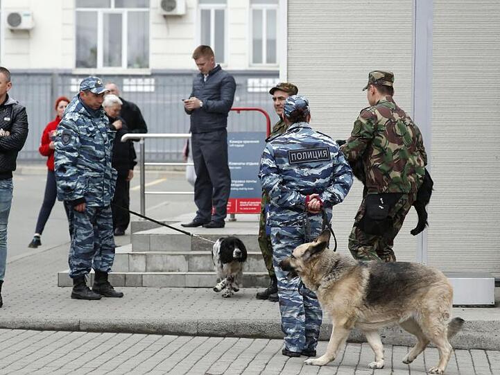 Polizisten mit Spürhunden patrouillieren in der Nähe des Bahnhofs Wladiwostok.