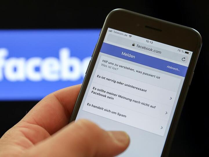 Ein Mann meldet einen Beitrag an Facebook. Das Online-Netzwerk will gegen Falschmeldungen bezüglich des Coronavirus härter vorgehen.