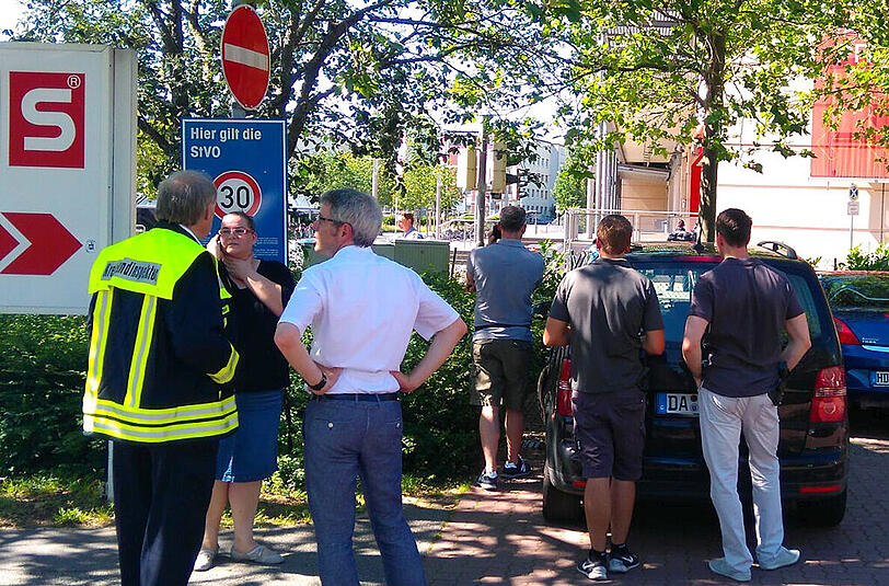 Passanten und Einsatzkräfte der Polizei stehen in Viernheim (Hessen) in der Nähe eines Kinos, in dem sich ein bewaffneter Mann verschanzt hat.