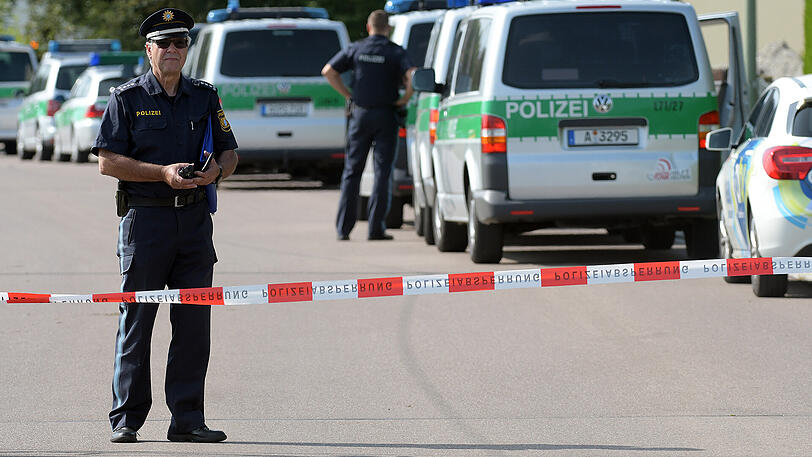 Polizisten stehen am Dienstag in Frauenstetten (Bayern) an einer Absperrung.