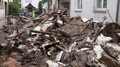 Schlamm und Unrat liegen zwischen den Häusern auf der Straße. Zahlreiche Häuser in dem Ort wurden komplett zerstört oder stark beschädigt.