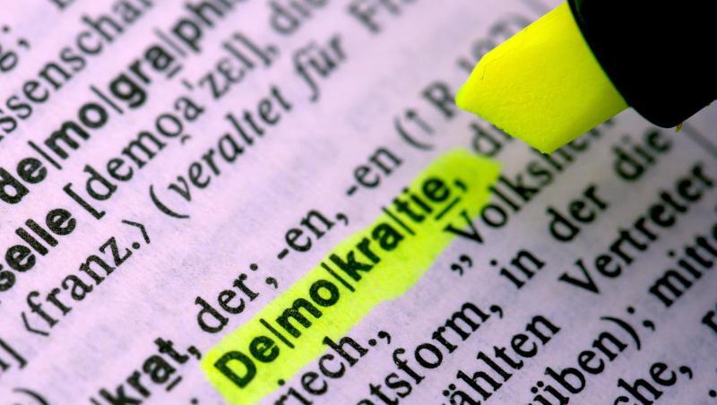 Jemand markiert im Duden das Wort "Demokratie". Foto: Federico Gambarini/Archivbild Jemand markiert im Duden das Wort "Demokratie". Foto: Federico Gambarini/Archivbild