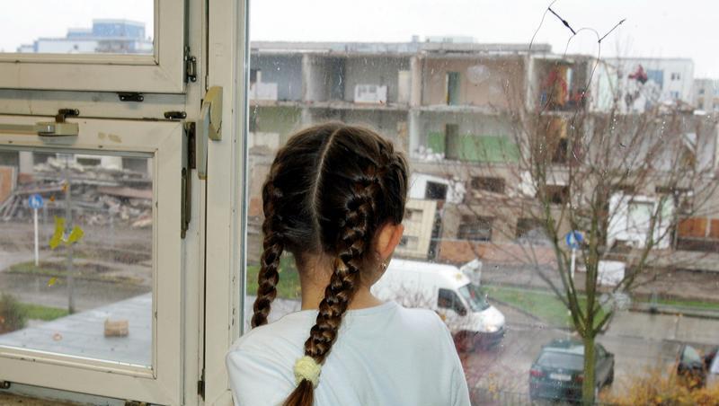Traurig schaut dieses kleine Mädchen aus dem Fenster Traurig schaut dieses kleine Mädchen aus dem Fenster