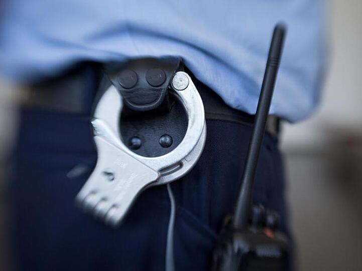 Blick auf die Handschellen eines Justizbeamten im Landgericht. Foto: Friso Gentsch/dpa/Symbolbild