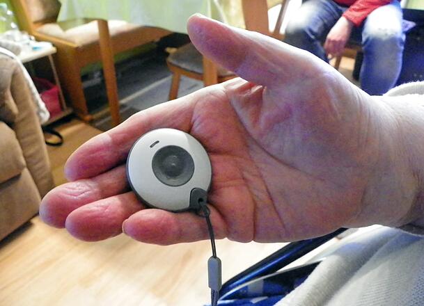 Eine Seniorin hält einen Hausnotruf in der Hand. Eine Seniorin hält einen Hausnotruf in der Hand.