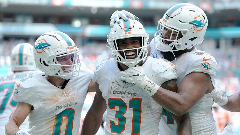 Raheem Mostert (M) jubelt mit seinen Teamkollegen Braxton Berrios (l) und Christian Wilkins (r) über seinen Touchdown.