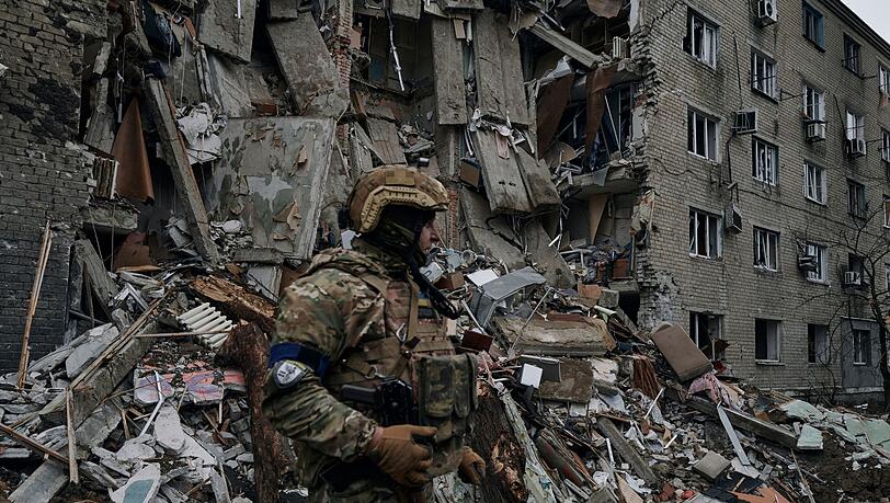 Ein ukrainischer Soldat steht in der Nähe eines durch den jüngsten Beschuss beschädigten Wohnhauses in Awdijiwka.