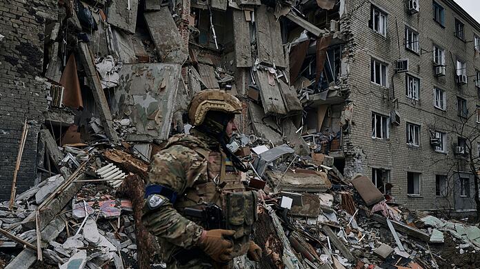 Ein ukrainischer Soldat steht in der Nähe eines durch den jüngsten Beschuss beschädigten Wohnhauses in Awdijiwka.