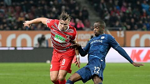 Augsburgs Emirdan Demirovic (l) und Bochums Christopher Antwi-Adjei kämpfen um den Ball.