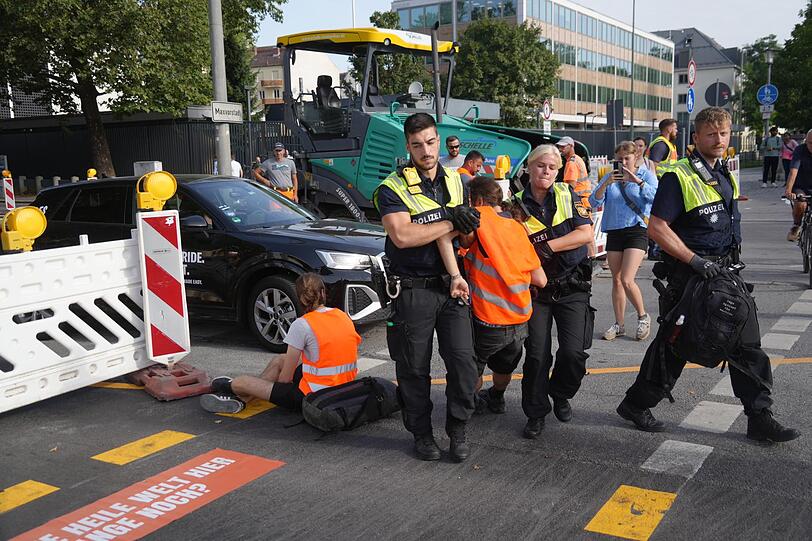 Die Polizei trägt einen Aktivisten der "Letzten Generation" von der Straße.