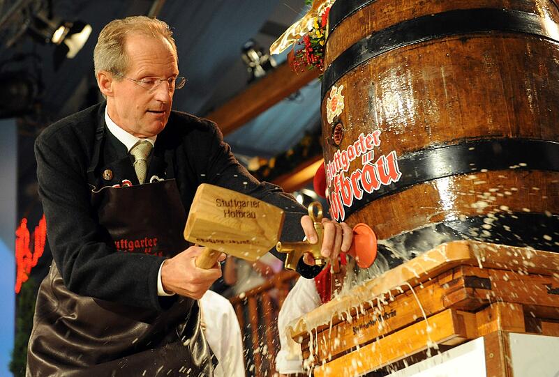 Der Stuttgarter Oberbürgermeister Wolfgang Schuster (CDU) schlägt am 24.09.2010 auf dem Cannstatter Wasen in Stuttgart zur Eröffnung mit zwei Schlägen einen Zapfhahn in das erste Bierfass.