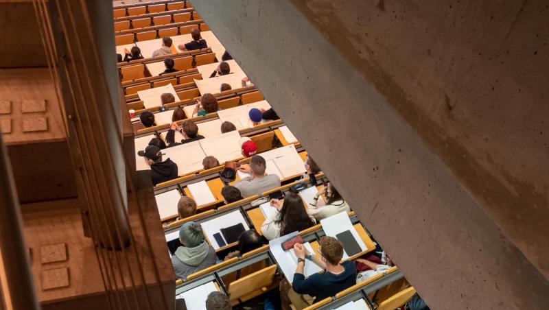 Studierende nehmen im Hörsaal an einer Vorlesung teil.