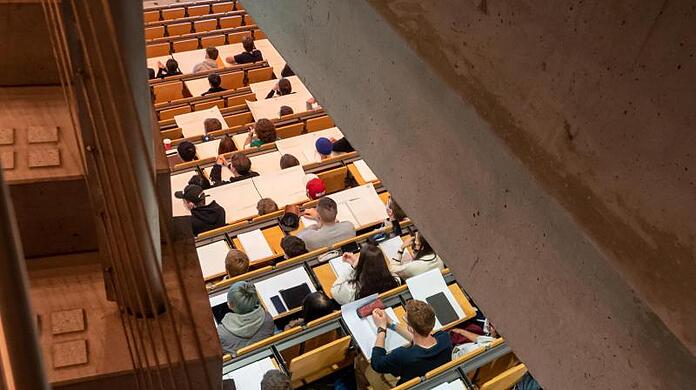 Studierende nehmen im Hörsaal an einer Vorlesung teil.