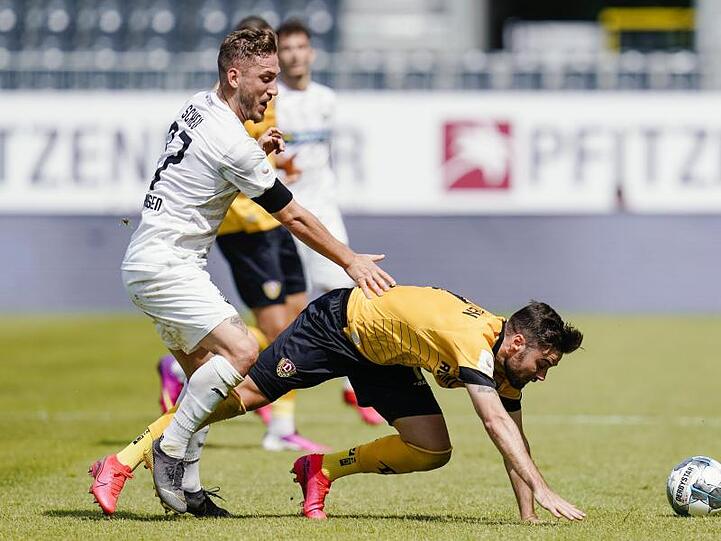 Dresdens Niklas Kreuzer (r) kommt im Zweikampf mit Sandhausens Robin Scheu ins Straucheln.