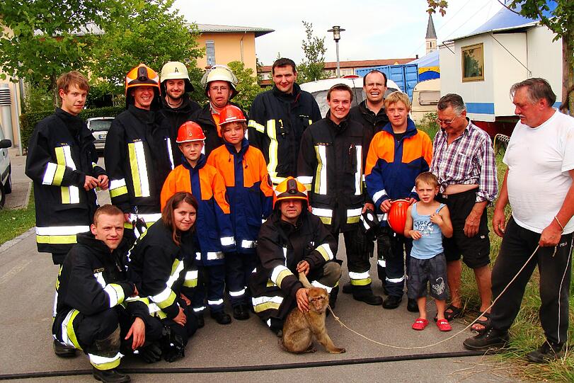 An der Leine: Berberaffen-Dame Minna mit ihrem Trainer (r.) und Feuerwehrleuten aus Altmühldorf.
