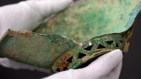 Ein Mitarbeiter hält eine Schale aus Bronze in den Händen. Foto: Sven Hoppe/dpa