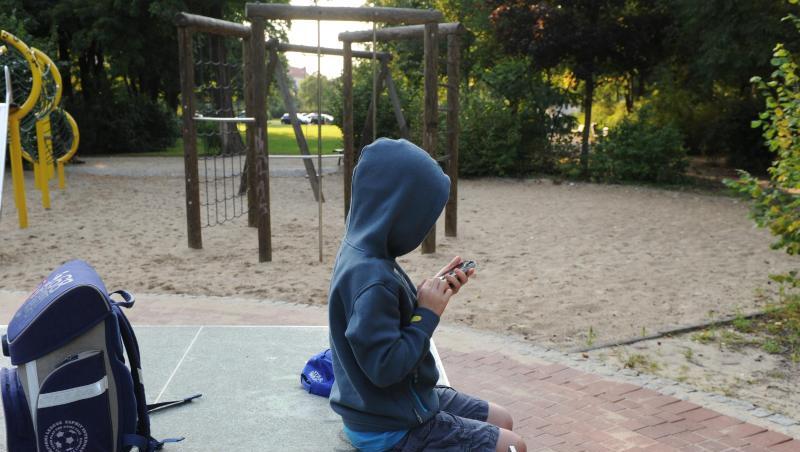 Ein Junge sitzt mit seinem Schulranzen auf einer Tischtennisplatte und spielt auf einem Smartphone. Foto: Jens Kalaene/dpa-Zentralbild/dpa/Archivbild Ein Junge sitzt mit seinem Schulranzen auf einer Tischtennisplatte und spielt auf einem Smartphone. Foto: Jens Kalaene/dpa-Zentralbild/dpa/Archivbild