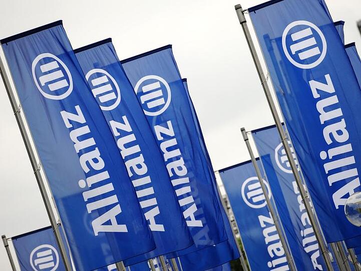 Fahnen mit dem Logo der Allianz. Foto: Andreas Gebert/dpa/Archivbild
