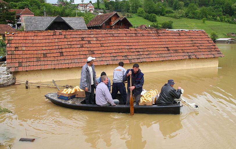 In Pozega, 200 Kilometer südwestlich von Belgrad, retten Ortsansässige einen Nachbarn aus seinem überfluteten Haus.