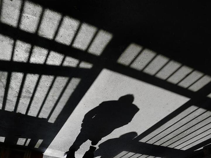 Der Schattenriss eines Mannes ist in der Justizvollzugsanstalt in einer Tür zu sehen. Foto: Felix Kästle/Archiv