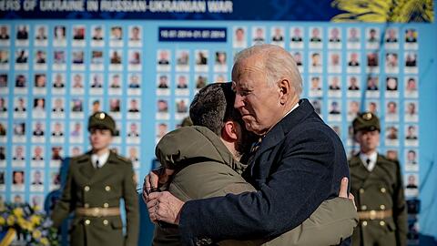 US-Präsident Joe Biden und sein ukrainischer Amtskollege Wolodymyr Selenskyj umarmen sich zum Abschied an der Gedenkmauer für die gefallenen Verteidiger der Ukraine.