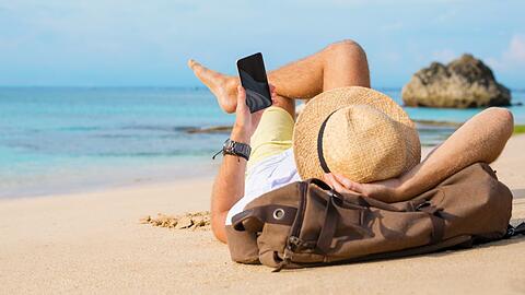 In Spanien am Strand - aber nicht ohne das Smartphone - davon träumen die meisten Deutschen laut einer Studie.