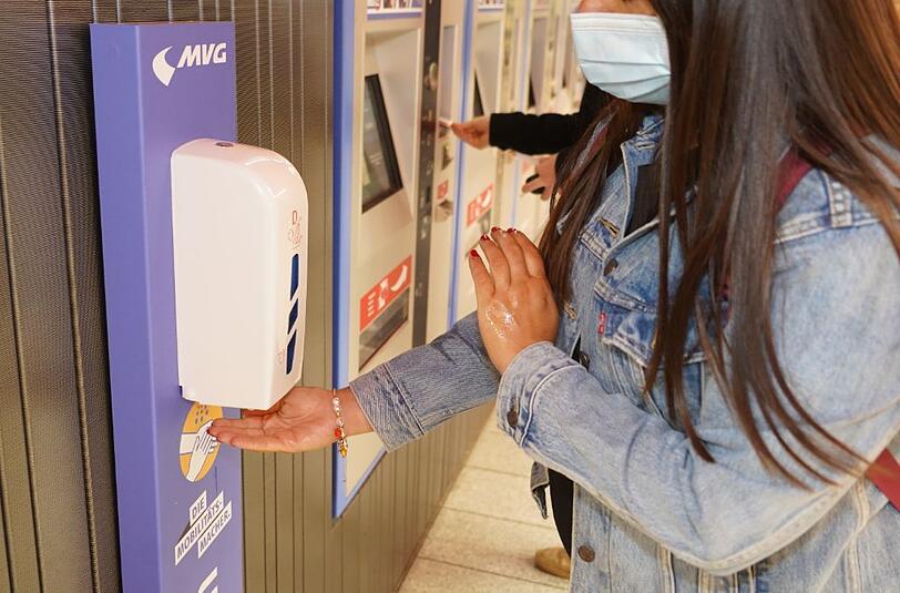 Eine Frau desinfiziert sich die Hände an der neuen Hygienestation am Marienplatz.