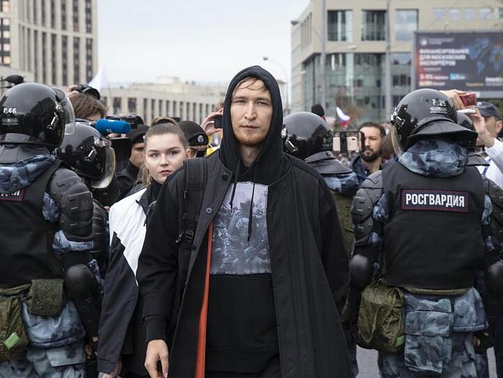 Mitglieder der russischen Elektro-Band IC3PEAK verlassen nach einem Auftritt die Proteste, während Menschen für faire und freie Wahlen demonstrieren.