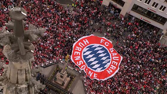 Die Anhänger des FC Bayern ziehen das Mega-Banner über den Marienplatz – unwissend, dass es sich dabei um ein Anti-Bayern-Banner handelt, das offenbar aus der Hand von 1860-Fans stammt. Die Anhänger des FC Bayern ziehen das Mega-Banner über den Marienplatz – unwissend, dass es sich dabei um ein Anti-Bayern-Banner handelt, das offenbar aus der Hand von 1860-Fans stammt.