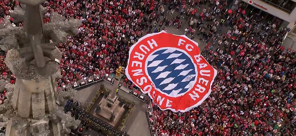Die Anh&auml;nger des FC Bayern ziehen das Mega-Banner &uuml;ber den Marienplatz &ndash; unwissend, dass es sich dabei um ein Anti-Bayern-Banner handelt, das offenbar aus der Hand von 1860-Fans stammt.