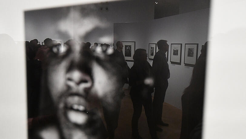 Besucher spiegeln sich in einer Fotografie des amerikanischen Fotografen Gordon Parks in Warschau (Polen). Besucher spiegeln sich in einer Fotografie des amerikanischen Fotografen Gordon Parks in Warschau (Polen).