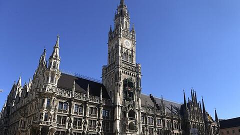 Vereinzelt gehen Menschen vor dem Rathaus über den Marienplatz. Foto: Felix Hörhager/dpa/Archivbild