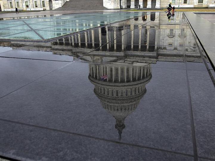 Nach einem Regenschauer spiegelt sich das Kapitol in Washington in nassen Steinplatten.