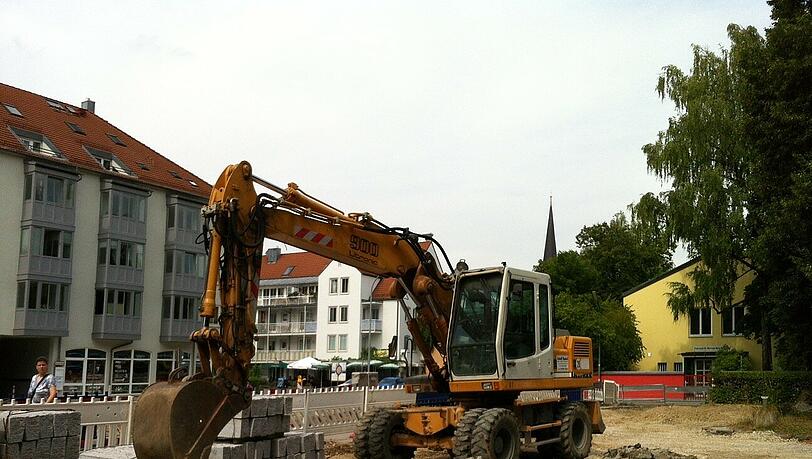 Ein Bagger arbeitet auf dem Wochenmarkt-Platz. Ein Bagger arbeitet auf dem Wochenmarkt-Platz.