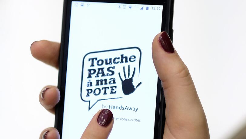 Auf einem Smartphone wird die belgische App "Touche pas a ma pote" geöffnet. Frauen können anonym per Knopfdruck Vorfälle von sexueller Belästigung melden.