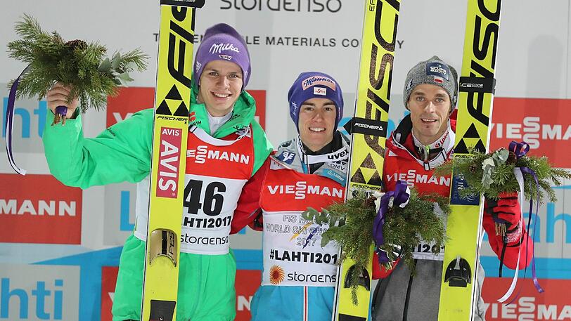 Stefan Kraft (M) aus Österreich bei der Siegerehrung. Links Deutschlands Andreas Wellinger (2. Platz) und rechts der Pole Piotr Zyla (Dritter).