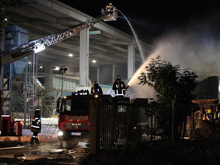 Einsatzkräfte der Feuerwehr löschen ein Feuer in einer Recycling-Firma. Foto: Schmelzer