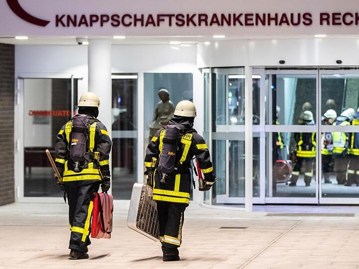 Einsatzkräfte der Feuerwehr vor dem Haupteingang des Krankenhauses.