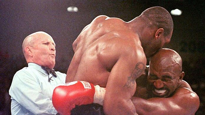 Tatort MGM Grand Hotel in Las Vegas: Am 28. Juni 1997 beißt Box-Ungeheuer Mike Tyson (Mitte) Evander Holyfield ein Stück Ohr ab, Ringrichter Mills Lane bricht daraufhin den Skandal-Kampf ab.