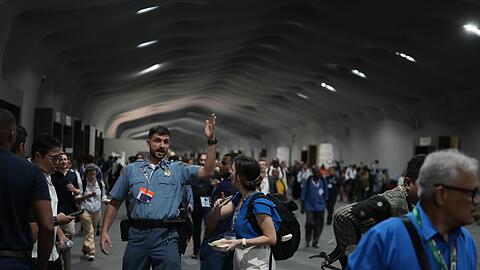 Menschen verlassen das Gelände der Weltklimakonferenz COP 30 wegen eines Feuers.