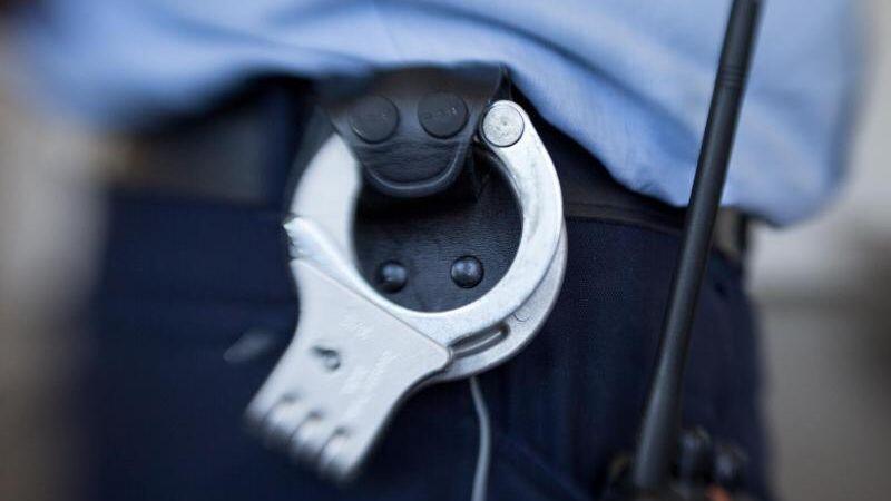 Handschellen hängen am Gürtel eines Justizbeamten. Foto: Friso Gentsch/dpa/Archivbild