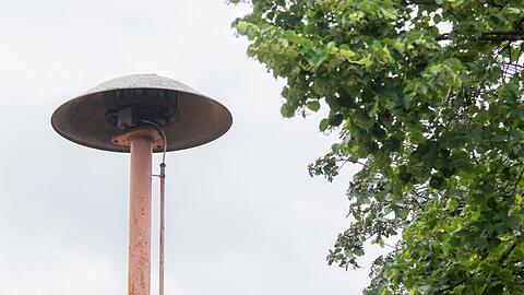 Eine Sirene steht auf einem alten Feuerwehrhaus.