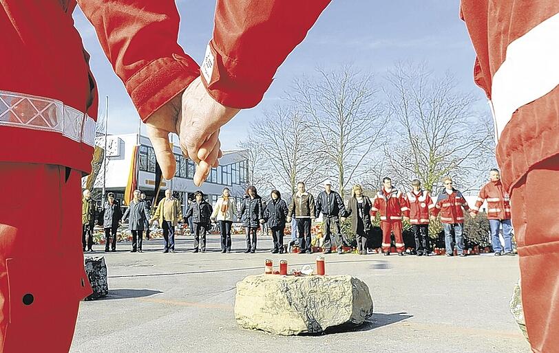Schweigeminute in Winnenden: Vor der Albertville-Realschule gedenken Rotkreuz-Helfer zusammen mit Angehörigen den Opfern.