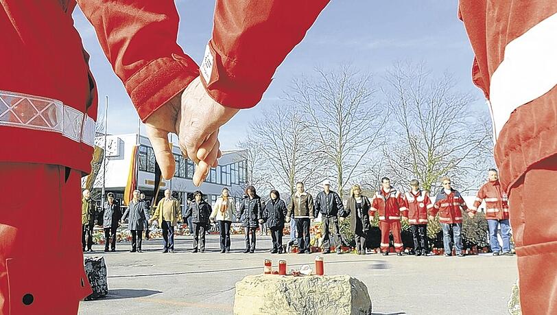Schweigeminute in Winnenden: Vor der Albertville-Realschule gedenken Rotkreuz-Helfer zusammen mit Angehörigen den Opfern. Schweigeminute in Winnenden: Vor der Albertville-Realschule gedenken Rotkreuz-Helfer zusammen mit Angehörigen den Opfern.