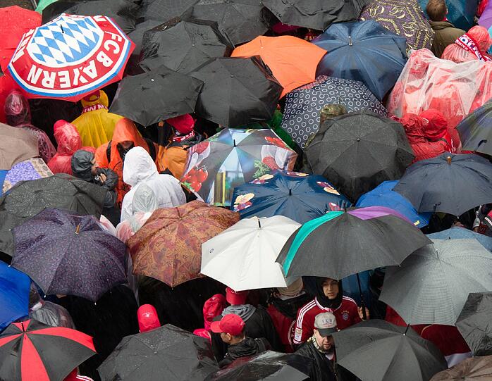 Das lange Warten auf die Pokalhelden. Es regnet und regnet und dennoch warten schon tausende Bayern-Fans auf das Eintreffen der Bayern-Stars. Die Bilder vom Marienplatz